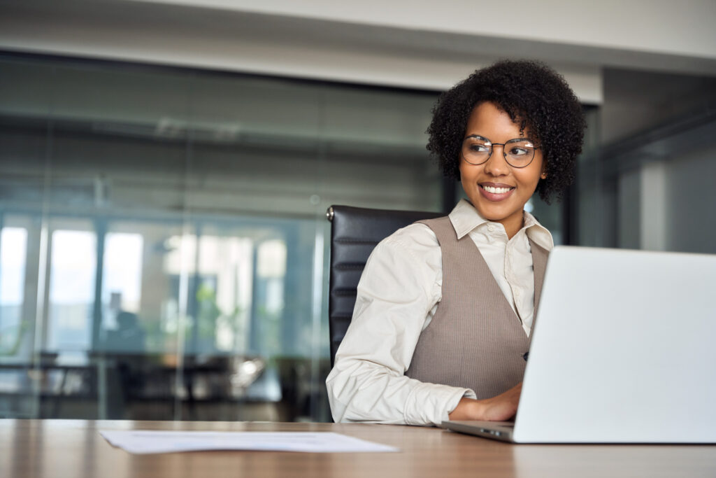 A professional businesswoman bank worker or hr manager, corporate employee looking away at work working on laptop computer in office thinking of future career.